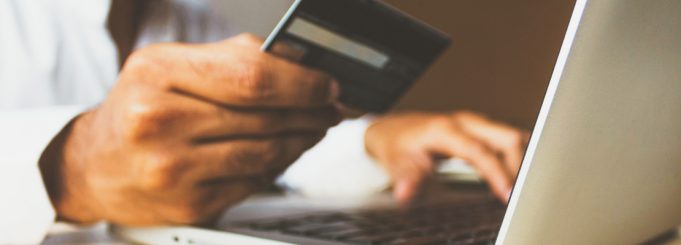 man holding his credit card to shop online